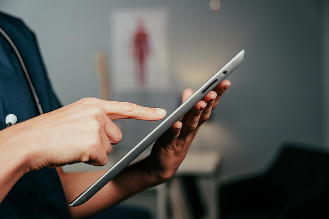 Healthcare worker looking at an electronic tablet