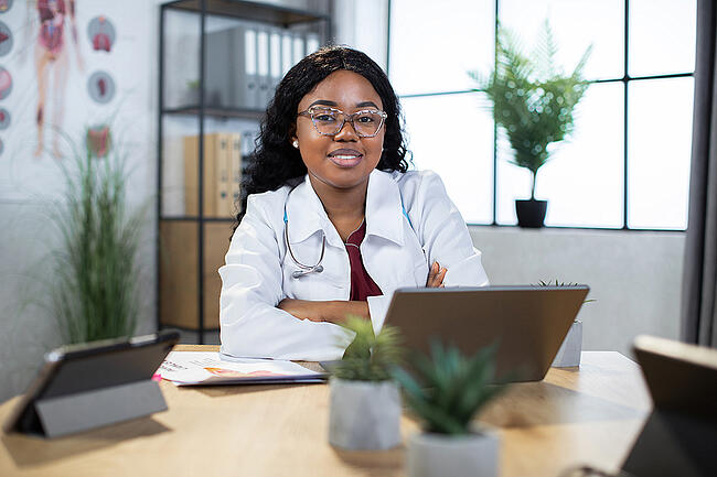 Nurse admin sitting at a desk behind a computer.