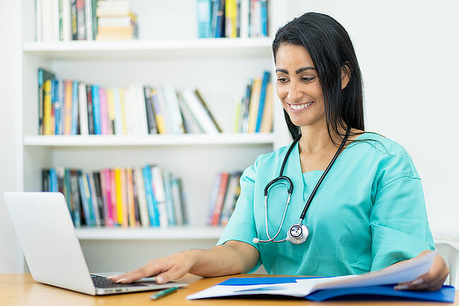 Smiling nurse manager working on the unit staff schedule.