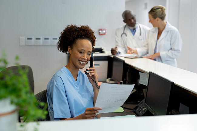 Smiling nurse manager creating a staff schedule.