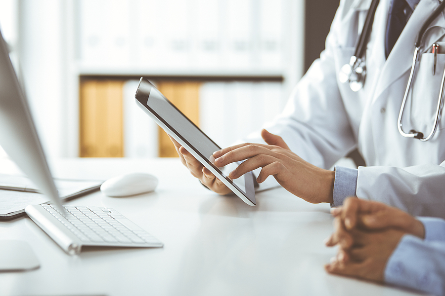 Healthcare staff looking over the staff schedule on a digital tablet.