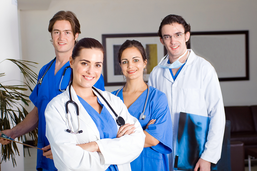 Group of medical workers standing in a hospital room.