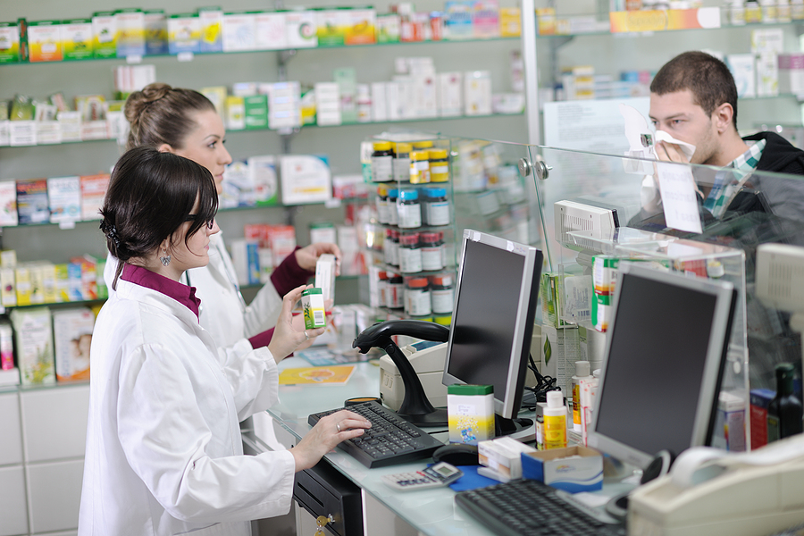 young pharmacist suggesting medical drug to patient in pharmacy drugstore