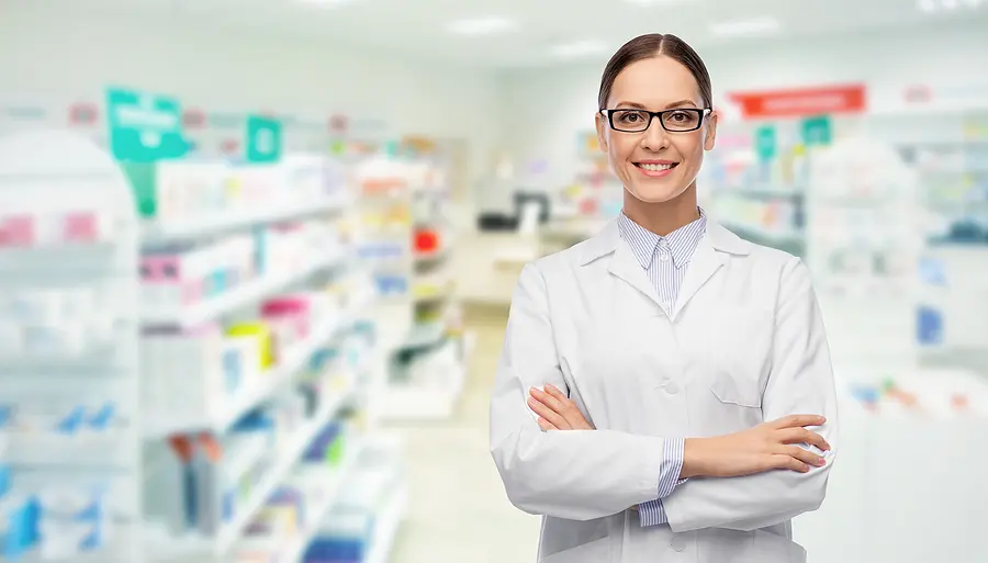 Female pharmacist standing in the isle of a pharmacy store.