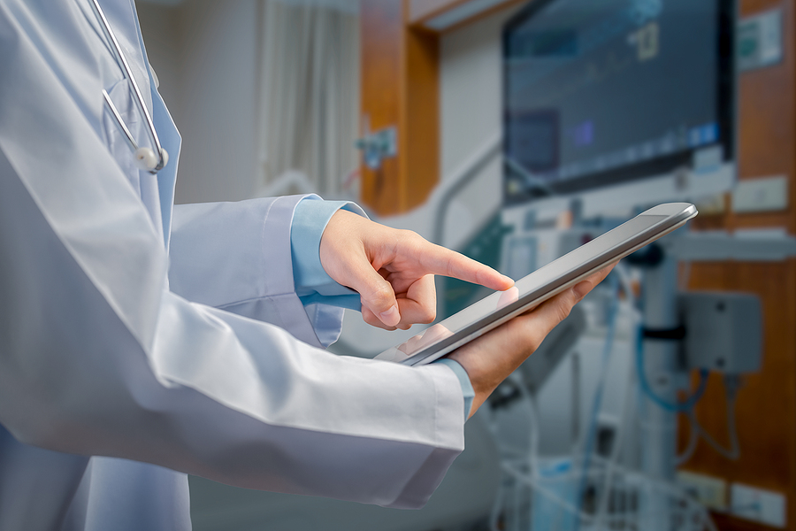 Hospital administrator reviewing unit labor reports on digital tablet.
